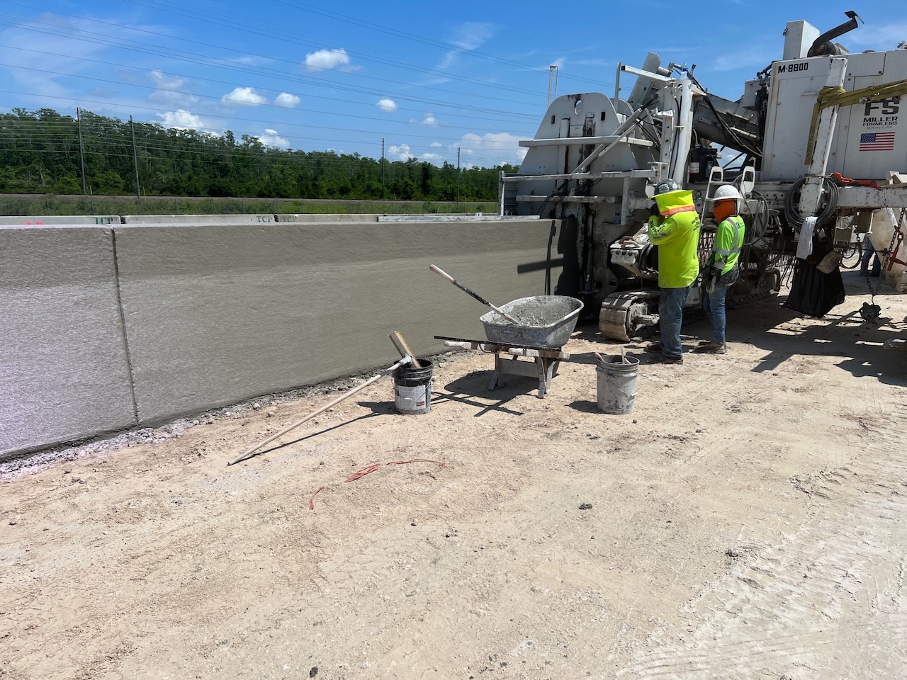 Crew working beside a newly finished concrete barrier