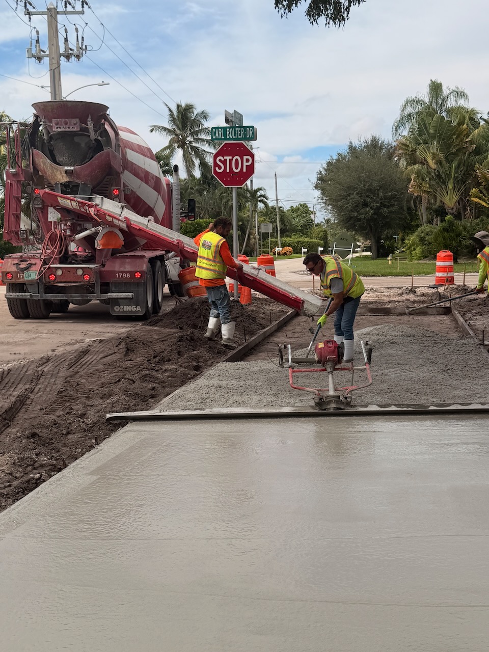 Crew pouring and finishing a concrete roadway