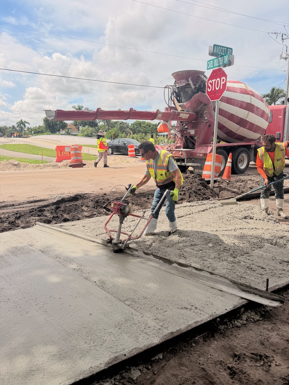 Crew finishing concrete near a mixer truck