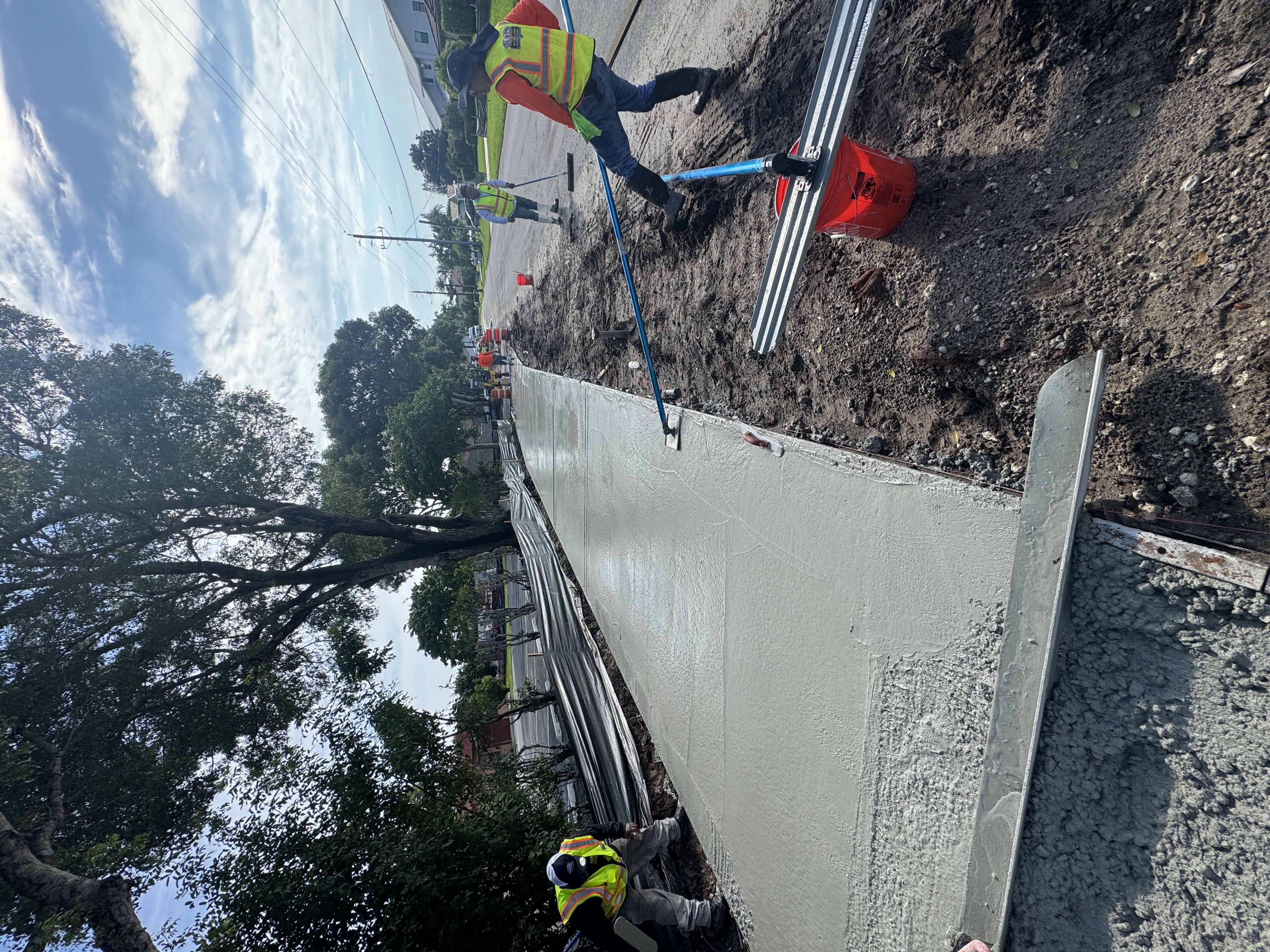 Concrete sidewalk construction underway with site equipment