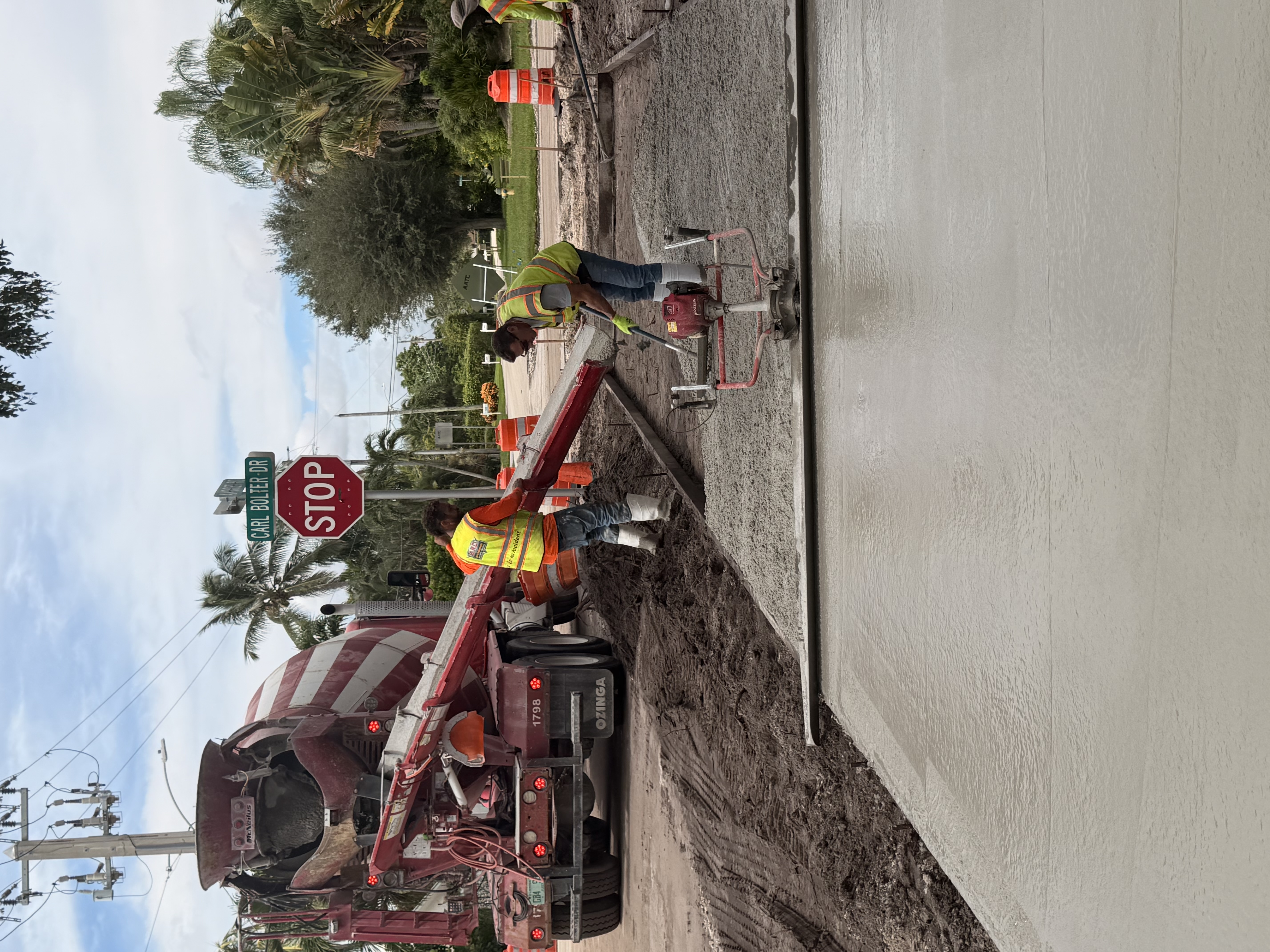 Crew working concrete beside a mixer truck